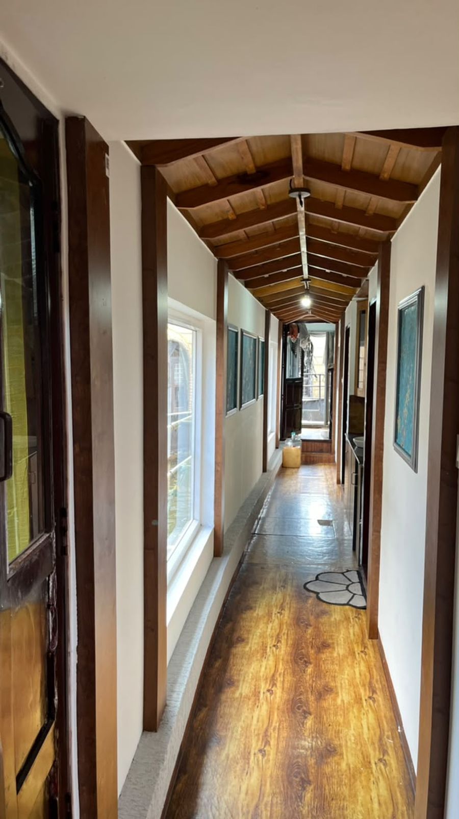 A wood-floored corridor with a timber ceiling inside a houseboat