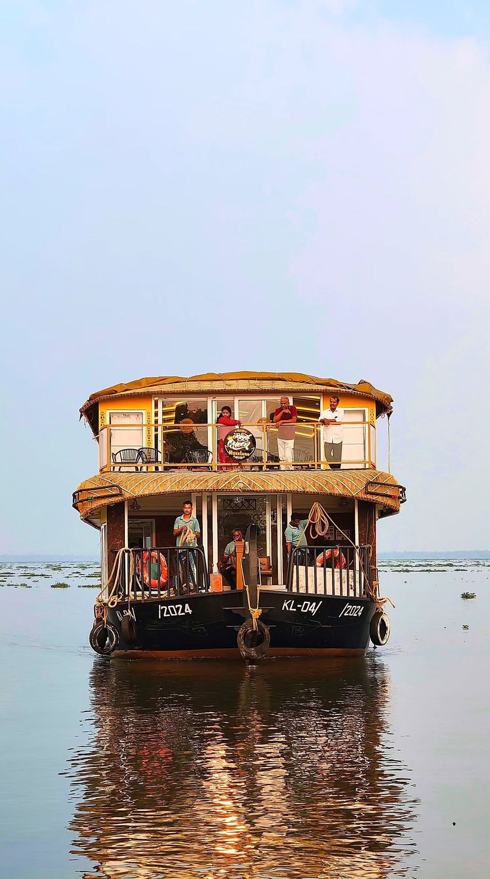 A two-deck houseboat on the calm open lake
