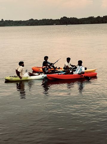 A group of friends in kayaks resting together on the lake