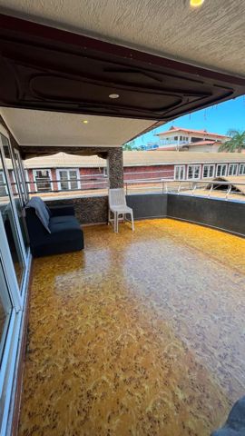 A covered open deck with a sofa and a view over the jetty