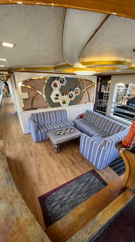 A lounge with blue striped sofas, a coffee table and a decorated feature wall