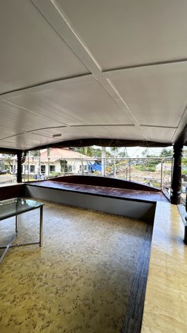A covered upper deck with a glass table and bench seating