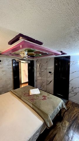 A bedroom with marble-look walls and dark wooden doors