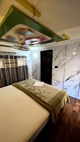 A bedroom with a double bed, marble-look walls and curtains