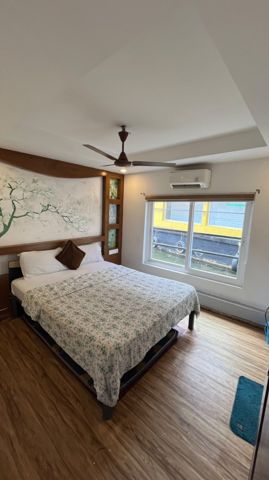 An air-conditioned cabin with a double bed, a painted blossom wall and a large window