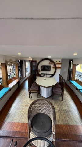 A cabin with a carved wooden ceiling, a round backlit headboard and a window